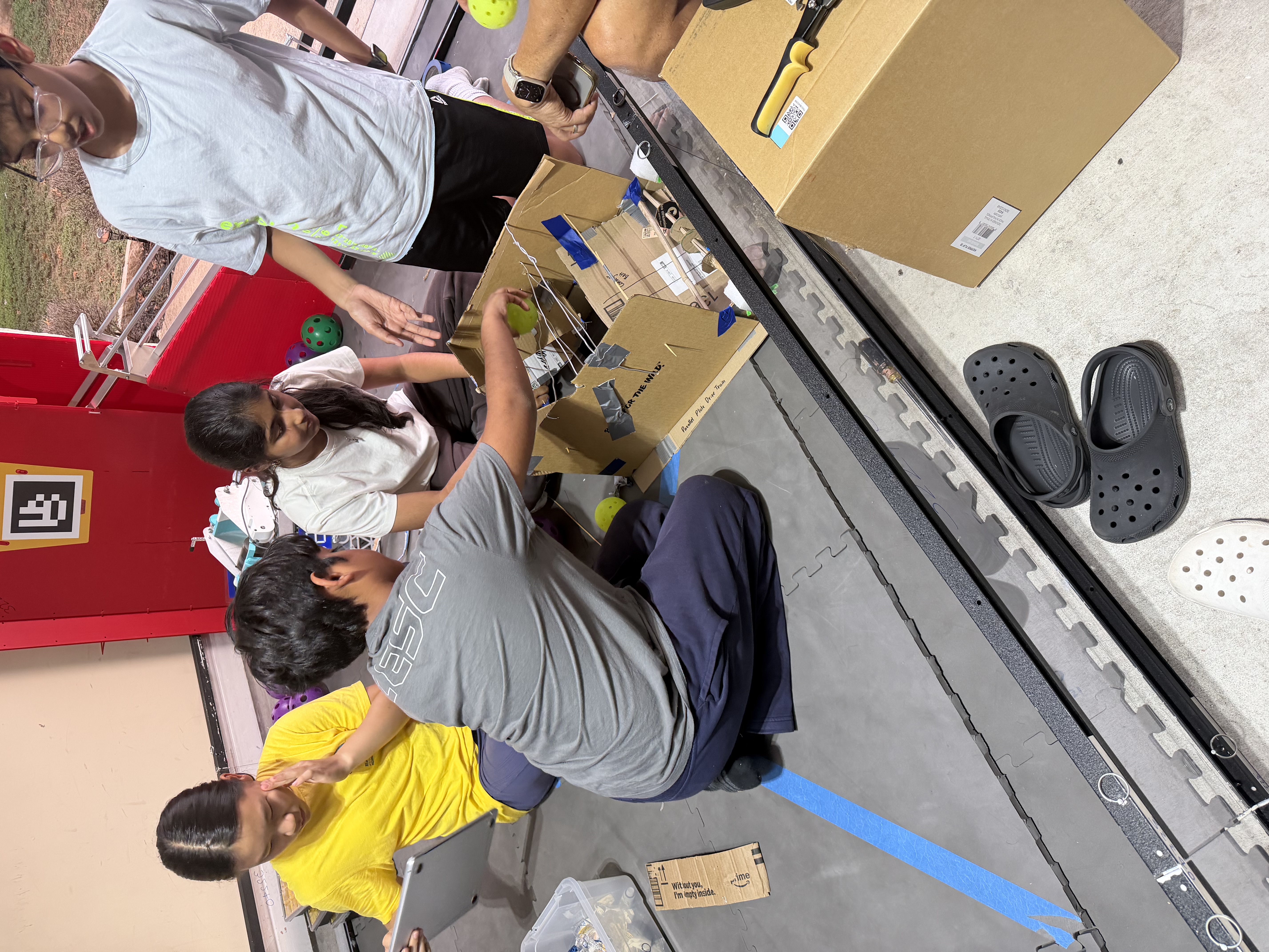 Students collaborate on a cardboard prototype in a robotics workshop