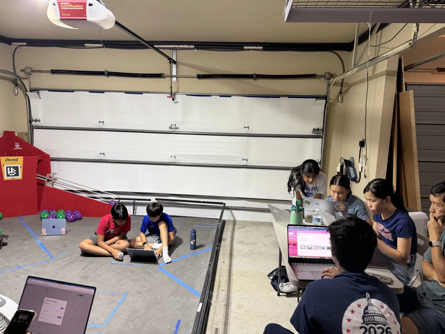 Penguinauts team members working together in their robotics workshop
